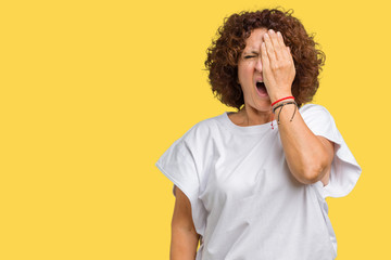 Poster - Beautiful middle ager senior woman wearing white t-shirt over isolated background Yawning tired covering half face, eye and mouth with hand. Face hurts in pain.