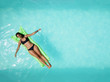 © Stocksy - Woman on green inflatable in the swimming pool
