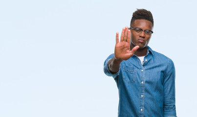 Young african american man over isolated background doing stop sing with palm of the hand. Warning expression with negative and serious gesture on the face.