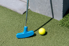 Yellow Golf Ball And Blue Stick On Green Lawn
