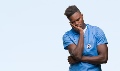 Poster - Young african american doctor man over isolated background wearing surgeon uniform thinking looking tired and bored with depression problems with crossed arms.