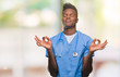© Krakenimages.com - Young african american doctor man over isolated background wearing surgeon uniform relax and smiling with eyes closed doing meditation gesture with fingers. Yoga concept.
