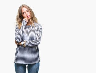 Sticker - Beautiful young blonde woman wearing stripes sweater over isolated background with hand on chin thinking about question, pensive expression. Smiling with thoughtful face. Doubt concept.