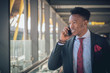 © EwebPhoto - Young businessman going to the airport talking by telephone and smiling