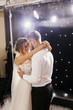 © sonyachny - Gorgeous bride and stylish groom gently dancing at wedding reception. Happy wedding couple performing first dance in restaurant. Romantic moments of newlyweds