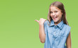 © Krakenimages.com - Young beautiful girl over isolated background smiling with happy face looking and pointing to the side with thumb up.