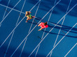 © ManuPadilla - Top view of young fitness male and female running on a blue race track. Runners