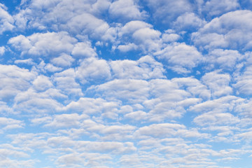 Many fluffy beautiful white clouds against blue sky background	