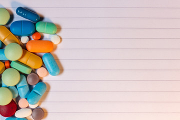 Poster - Pills and colored capsules on a neutral striped background.