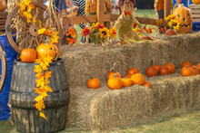 Two Levels High Of Hay Bails Holds A Bunch Of Small Pumpkins With Other Fall Decorations.