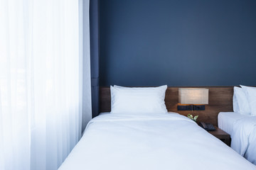 Wall Mural - Close-up of white pillow on bed decoration with light lamp and digital telephone set in hotel bedroom interior.