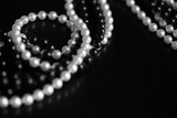Fototapeta Łazienka - Necklace of black and white beads on a dark background close up. Black and white