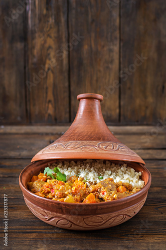 Fotomural Traditional tajine dishes, couscous and fresh salad on rustic wooden table