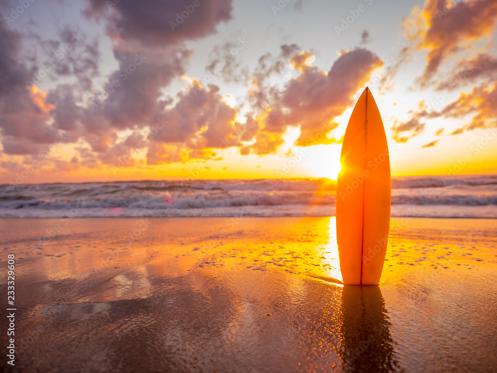 surfboard on the beach in sea shore at sunset time with beautiful light - obrazy, fototapety, plakaty 
