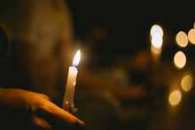 Soft Focus Of People Lighting Candle Vigil In Darkness Seeking Hope, Worship, Prayer