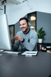 © bnenin - Casual smiling businessman with headset at work in modern office. Copy space.
