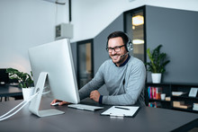 Smiling Casual Business Man With Headset Working On The Computer.