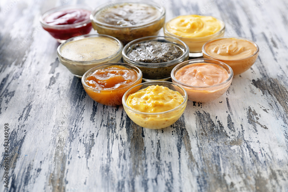 Different tasty sauces in bowls on wooden table