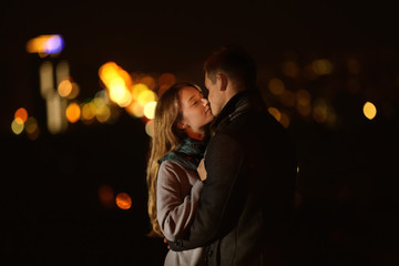 Wall Mural - Loving young couple kissing on romantic date at night