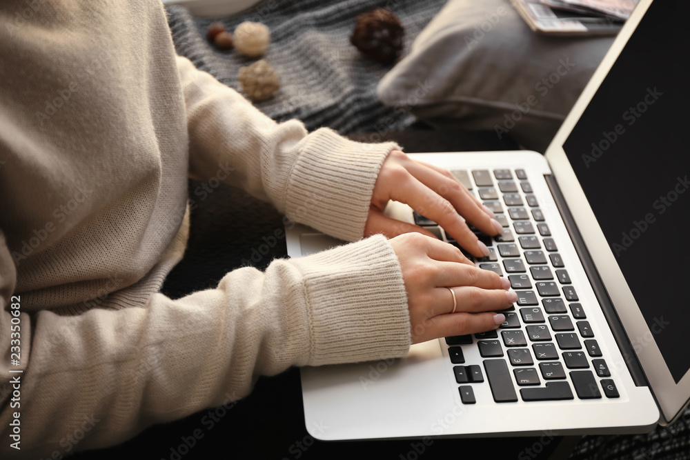 Woman using laptop at home, closeup