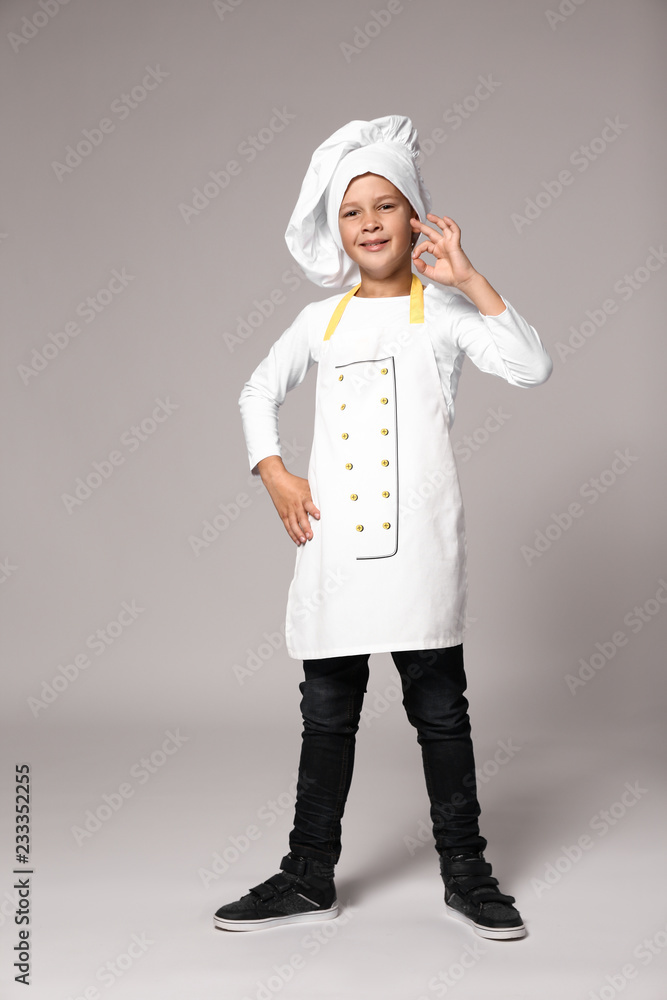 Cute little chef on grey background