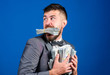 © be free - Steal money. Thief with piles dollars money. Earnings surprise concept. Man bearded businessman hold pile money blue background. Businessman surprised feels like thief with lot of cash in hands