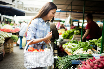 Young woman buying vegetables at the market.