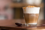Latte macchiato coffee on wooden desk in coffee shop