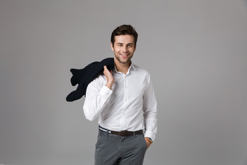 Canvas Print - Image of caucasian businessman 30s smiling and holding jacket over his shoulder, isolated over gray background