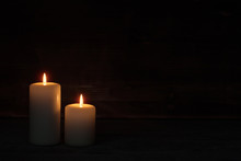 Burning Candle On Old Wooden Background