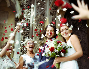 Wall Mural - Family throwing rose petals at the newly wed bride and groom