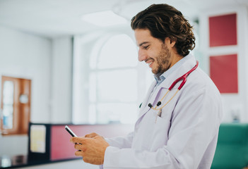 Wall Mural - Male doctor using his smartphone