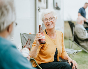 Wall Mural - Happy senior woman with a bottle of beer