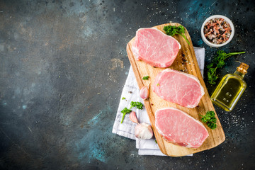 Cooking meat dinner background. Raw fresh meat, pork brisket boneless steak, with spices, herbs, olive oil, top view