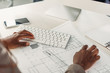 © LIGHTFIELD STUDIOS - cropped view of african american female architect using compute desk with blueprints