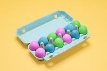 Dozen Dyed Easter Eggs In Carton Container.  Pastel Painted Easter Eggs In Egg Crate On A Bright Pastel Yellow Background With Copy Space And Room For Text