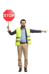 Wall Mural - Man with a safety vest holding stop sign and pointing