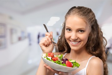 Wall Mural - Young woman with bowl of salad on healthy food background