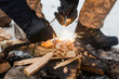 Male hand starts fire with magnesium fire steel, fire striker
