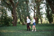 © soleg - young couple walking in the forest and playing guitar, summer nature, bright sunlight, shadows and green leaves, romantic feelings