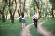 © soleg - young couple walking in the forest and playing guitar, summer nature, bright sunlight, shadows and green leaves, romantic feelings