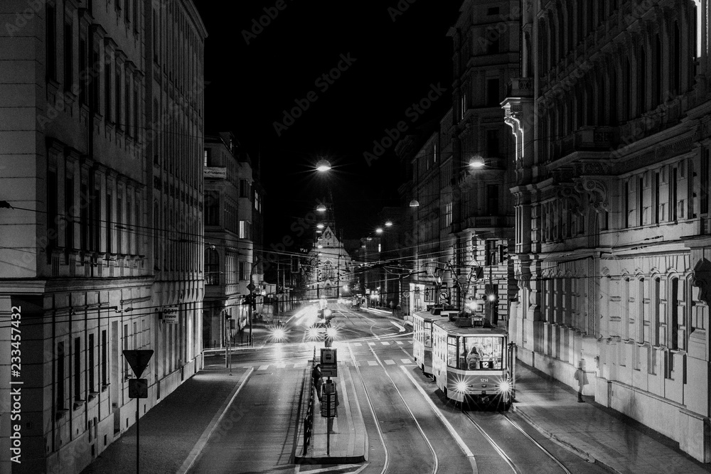 Tram stop Šilingrovo náměstí in Brno passing through public transport through night long street captured in black and white combination - obrazy, fototapety, plakaty 