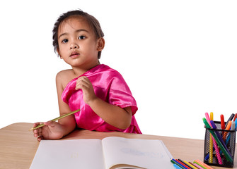 Cute cheerful child drawing using color pencil while sitting at table isolated on white background