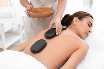 Poster - Beautiful young woman getting hot stone massage in spa salon