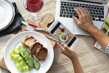 Wall Mural - Blogger taking photo of food with mobile phone, closeup