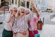 Happy White-haired Ladies Spending Time Together While Walking Through The City