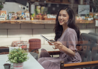 Sticker - happy woman using credit card to shopping online with tablet at cafe