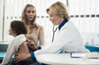 © Yakobchuk Olena - Concept of professional consultation in healthcare system. Side on waist up portrait of pediatrician woman examining girl by stethoscope in medical office