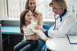 Concept of professional consultation in healthcare system. Waist up portrait of pediatrician woman listening to lungs of smiling girl by stethoscope in medical office