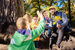 © zinkevych - School teacher. Joyful positive teacher holding a tree branch while talking to his pupils
